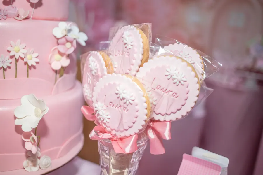 Personalized cookies beside a pink cake