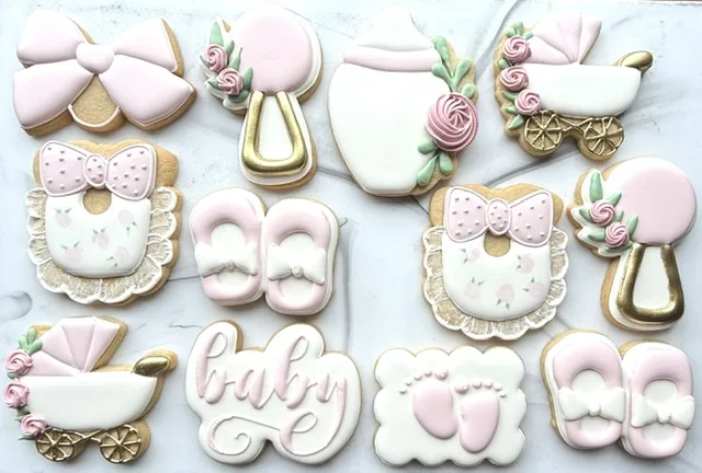 Baby shower cookies with bows, rattles and roses in pink