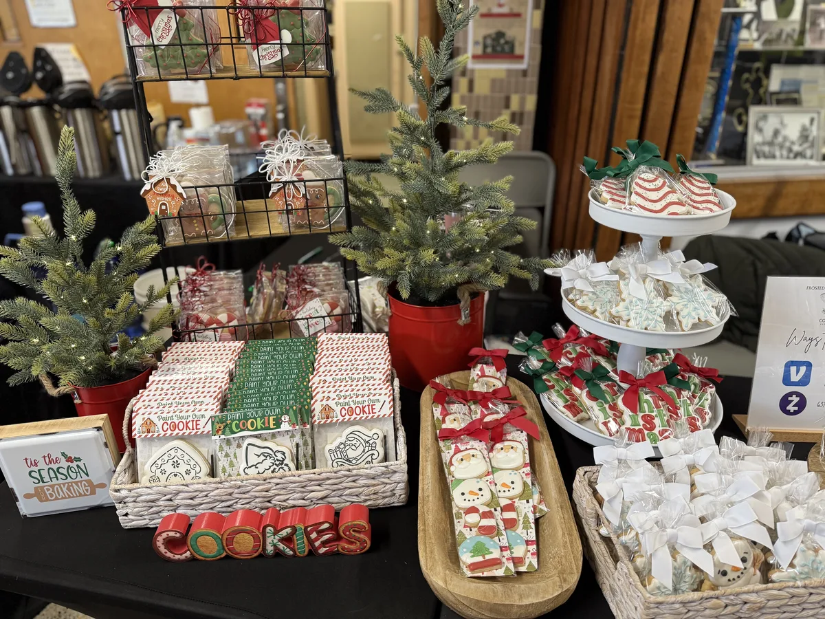 Jen's holiday fair table with wrapped cookies, mini trees and a tiered stand