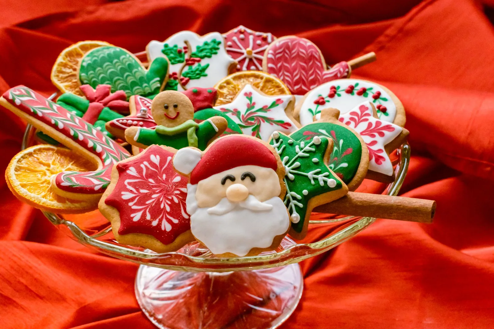 Christmas sugar cookies with Santa, mittens and snowflakes on a red backdrop
